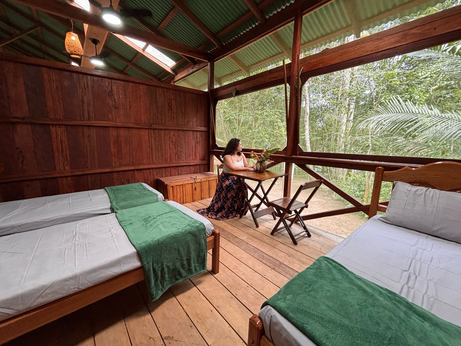 amazon camp lodge, vista interna do quarto, uma mulher sentada na cadeira observando a floresta amazônica