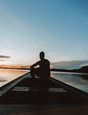 uma pessoa na canoa no pôr do sol no rio negro